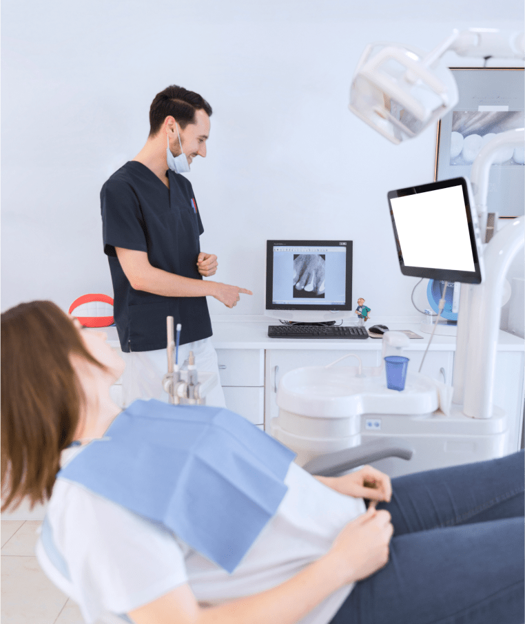 Dentist Explaining A Teeth X-ray On The Screen To Female Patient