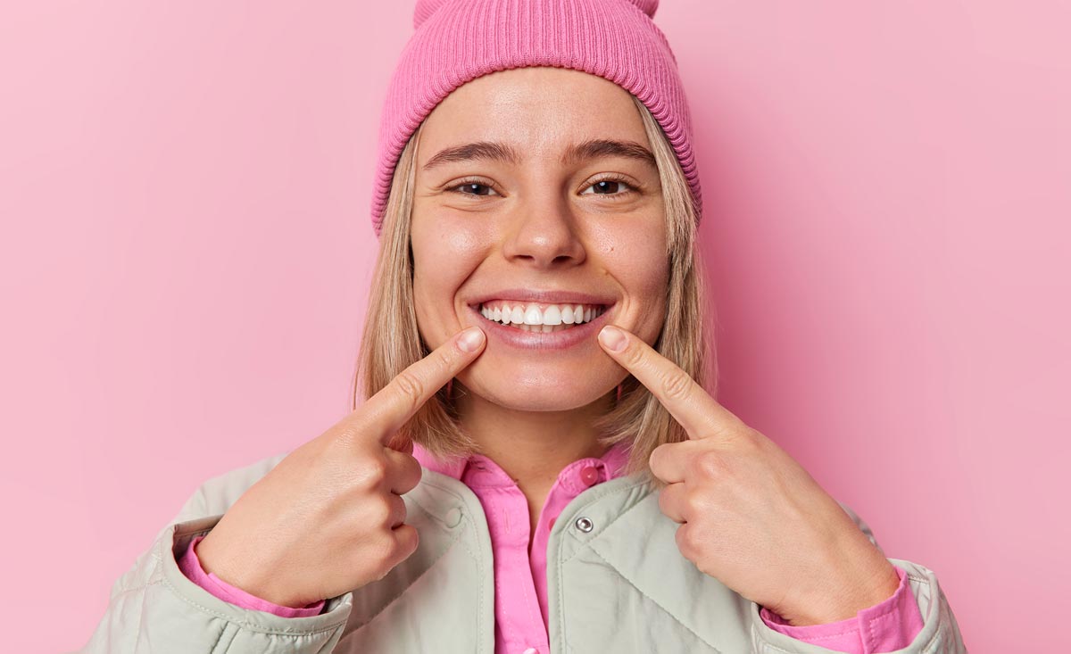 Girl Pointing At Her Teeth After Periodontal Treatment In Indianapolis, IN