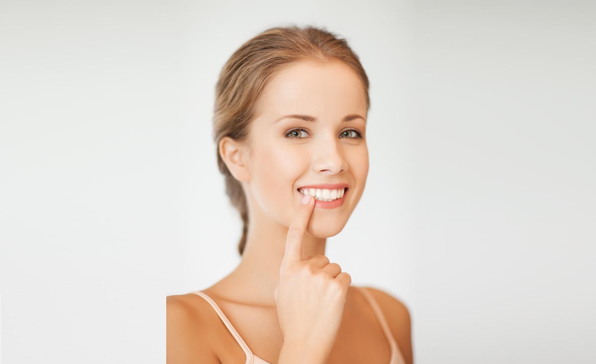 Woman Pointing At Her Teeth