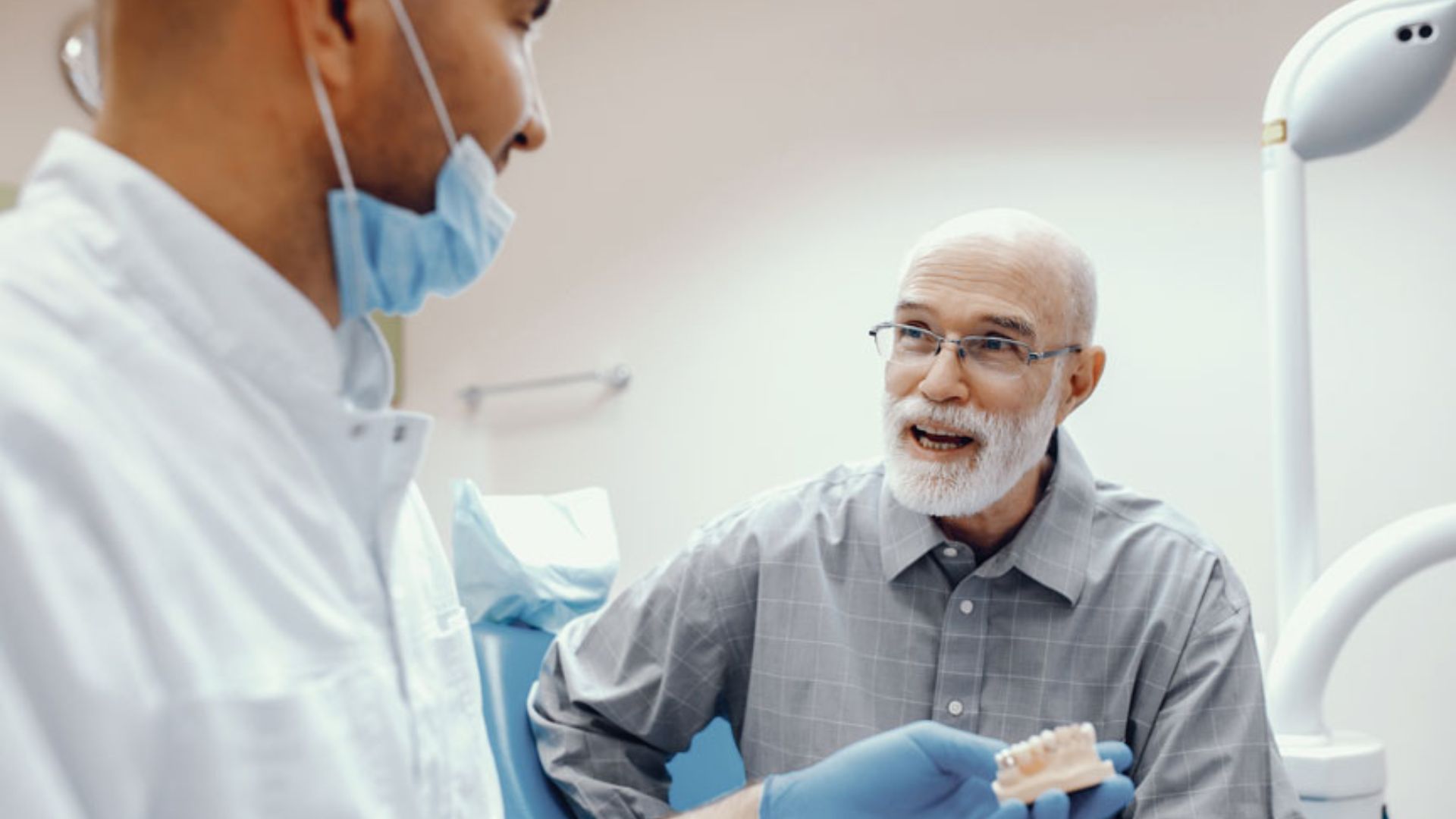 Dentist Explaining Dentures To Senior Patient
