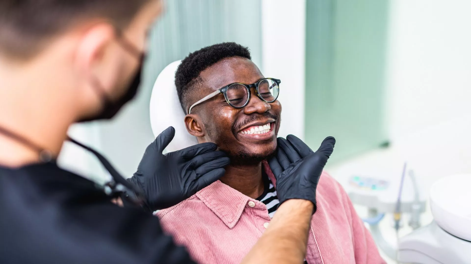 Dentist Examining Smiling Patient in Dental Chair